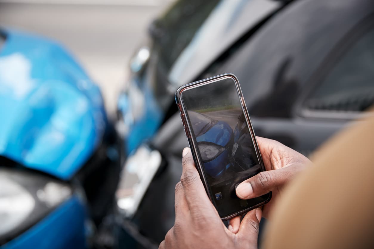 Motorist Involved In Car Accident Taking Picture Of Damage For Insurance Claim