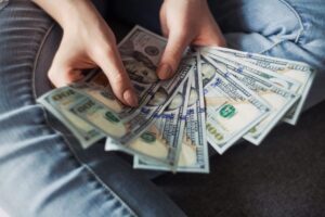 person holding several $100 bills