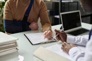 injured person signing legal documents to recover compensation with the help of an attorney